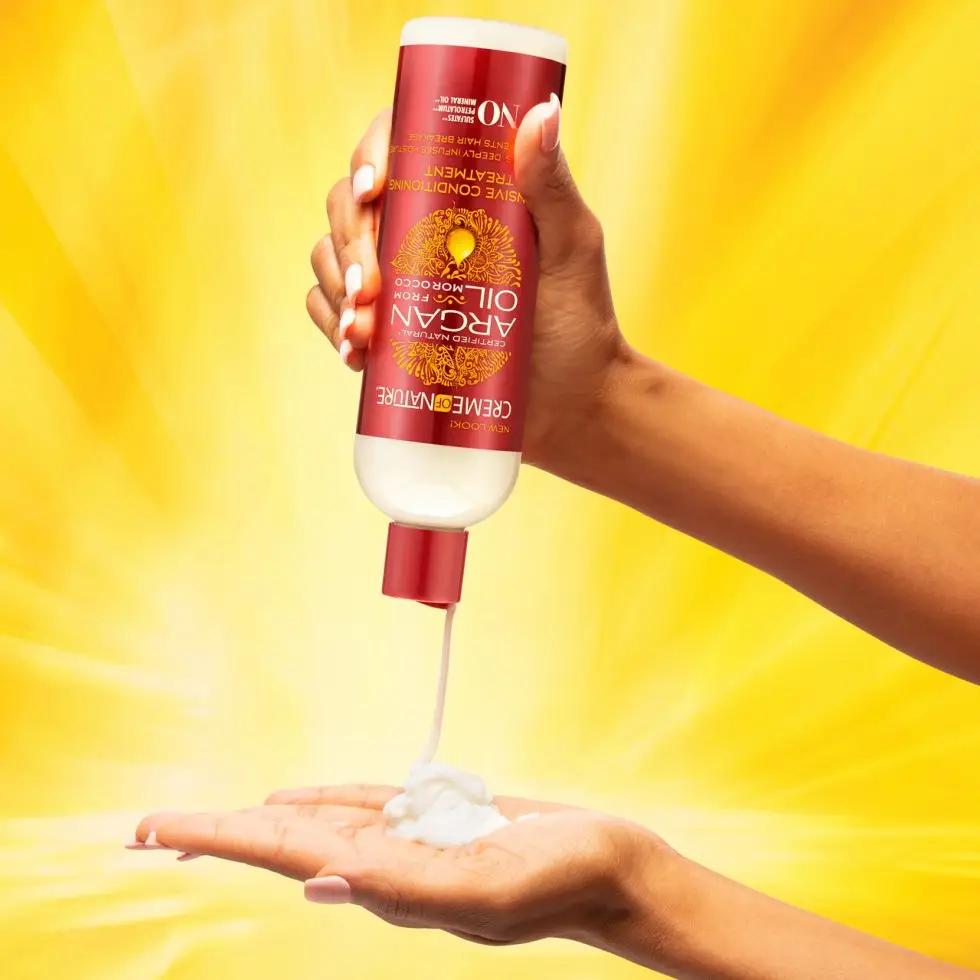 Image of a hand squeezing the contents of the product bottle into another hand on a yellow background